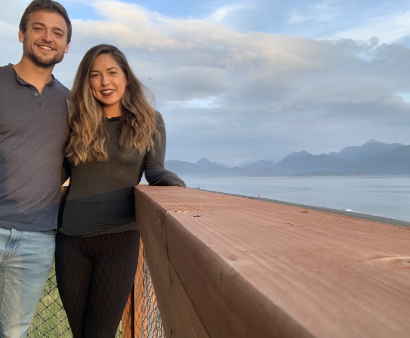Chazlyn and Nicolas on a deck above a mountain lake